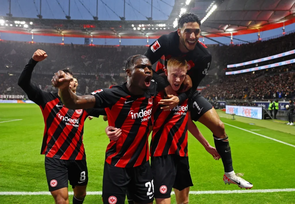Hugo Larsson celebrates with Eric Junior, Dina Ebimbe and Omar Mamouche after scoring Eintracht Frankfurt's third goal